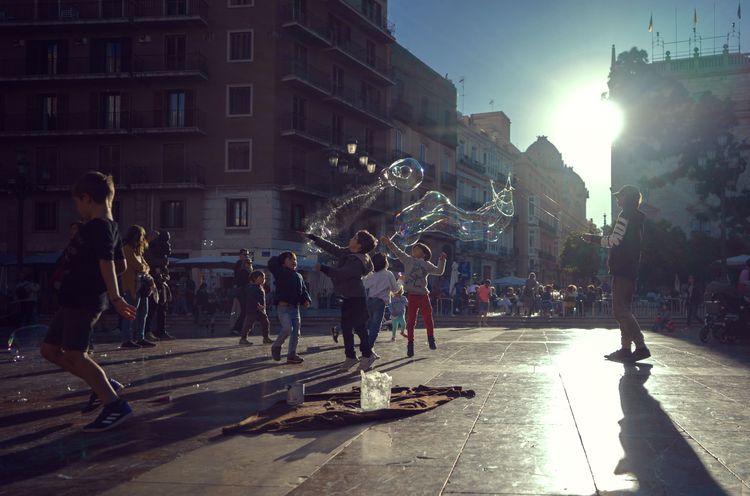 Children playing with bubbles on the street