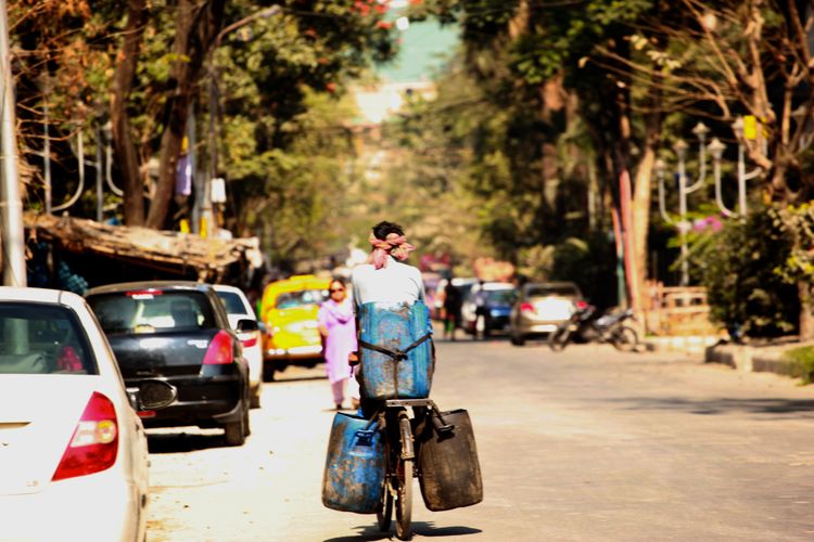 Indian biker cycling away in the street of Calcutta