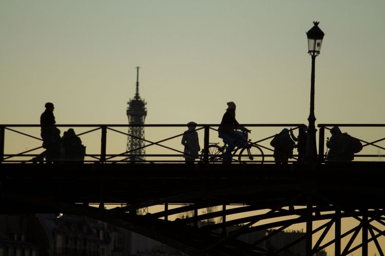 Silhouettes passing by a bridge looking at the Eiffel Tour, Paris 2016