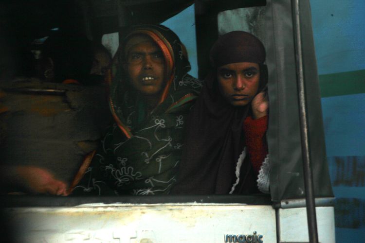 Woman and young girl travelling at the back of a truck